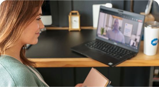 A female ADT intern sits at her laptop watching a video.