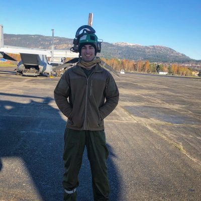 Picture of David standing in front of a Marine Corps Airplane.