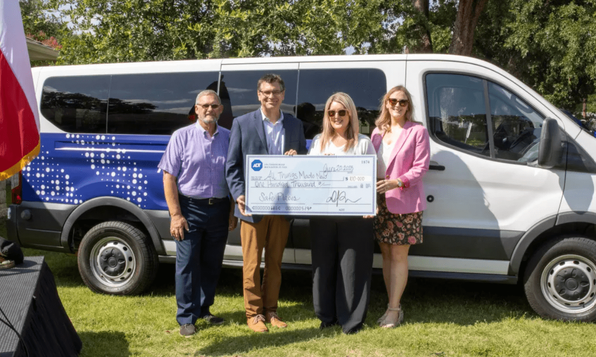 Irving Mayor Rick Stopfer (left) and All Things Made New Executive Director Michelle Flores (second from right) accept a $100,000 donation from ADT's Dave Scott and Amber Weaver. ADT also donated the passenger van in the background and two ADT+ Security Systems.